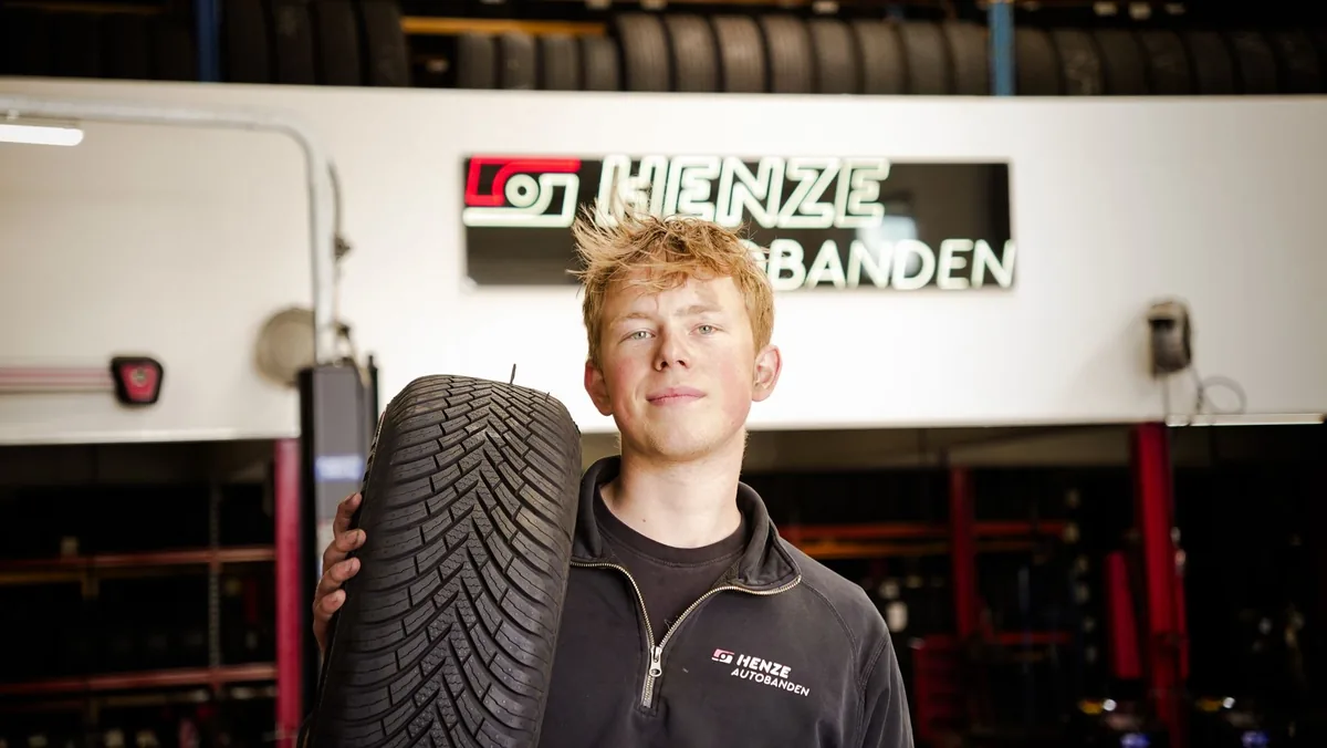 Medewerker van Henze Autobanden met een band in de werkplaats